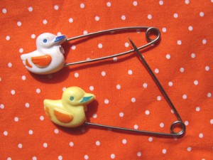 Safety pins, or more frequently, a unique model with an additional safe cover.