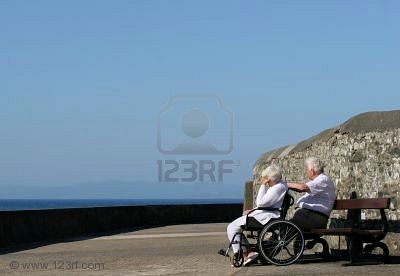 506354-elderly-woman-in-a-wheelchair-with-her-hand-on-her-head-seemingly-depressed-and-sitting-next-to-an-e