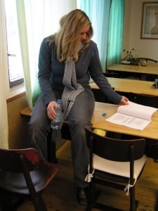 A Mommy Dom She is reading something while donning a blue coat and tie.