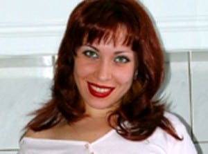 A gorgeous woman, she is posing for shots while wearing a white dress.