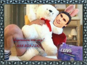 A Diaper Man is sleeping in bed with a teddy bear and has a childlike appearance.