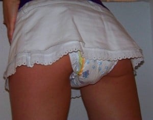 Standing and sporting a white diaper, the lovely girl has a hot and seductive appearance.