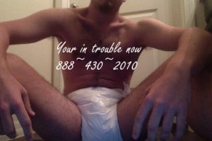 A beautiful man wearing a diaper is sitting on the ground looking hot and sensual.