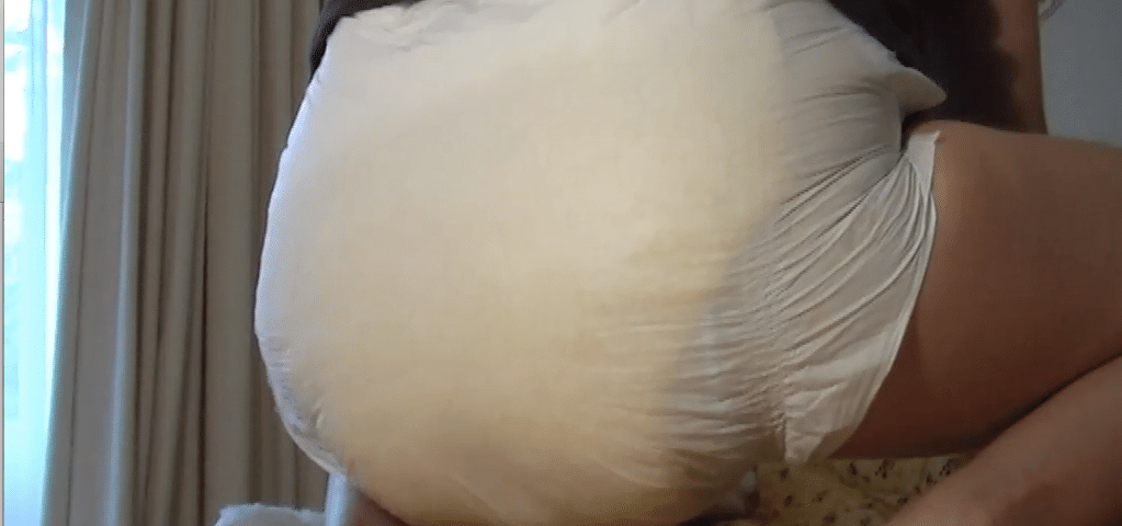 A hot-looking, sexy man is seated in the bed, and the diaper is soft.
