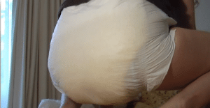 A hot-looking, sexy man is seated in the bed, and the diaper is soft.