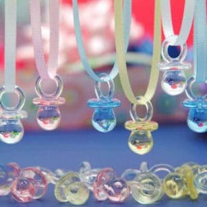 In the image, a baby shower pacifier necklace is displayed. It comes in many colours.