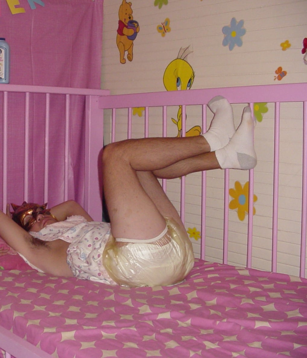 He is a baby man and is laying in the cot.