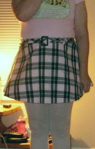A lovely female is standing with enormous boobs and is dressed in sexy clothes. For the photo session, she is standing.
