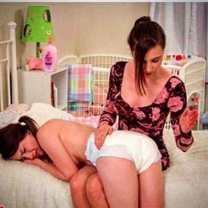 A sexy mother is wagering a sexy child, and the child is lying down the mother's leg.