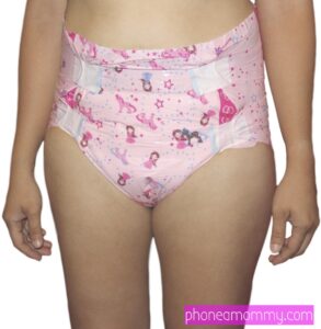A woman engaged in diaper fetish stands in front of the picture session wearing the pink attire.