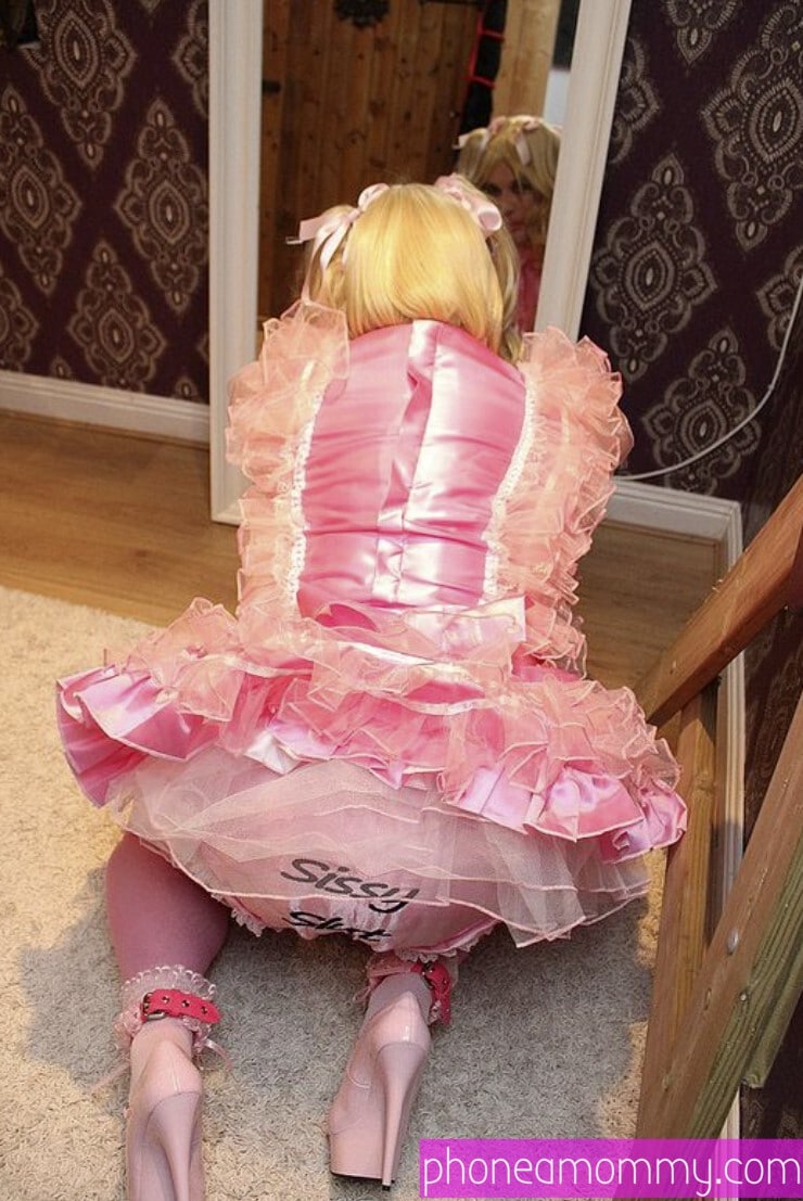 A diaper boy is seated on the ground, showing off his back while donning the pink sexy drees.