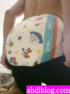 A sexy lad wearing a diaper is doing the backwards-turning stance.